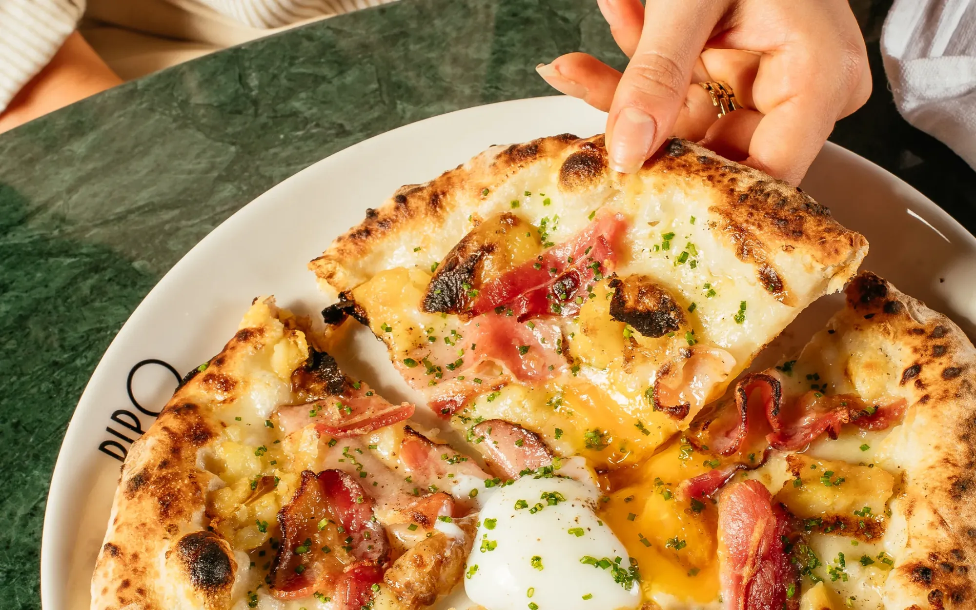 Pizza Batatinha servida na bancada de mármore verde